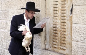 (120923) -- JERUSALEM, Sept. 23, 2012 (Xinhua) -- An orthodox Jew performs the ritual of Kapparot in Jerusalem's Mea Shearim neighborhood, Sept. 23, 2012. The ritual is practiced by orthodox and religious Jews ahead of Yom Kippur, the Jewish Day of Atonement. During the ritual people move around a live chicken over one's head three times, symbolically transferring one's sins to the chicken. (Xinhua/Ariel Jerozolimski)